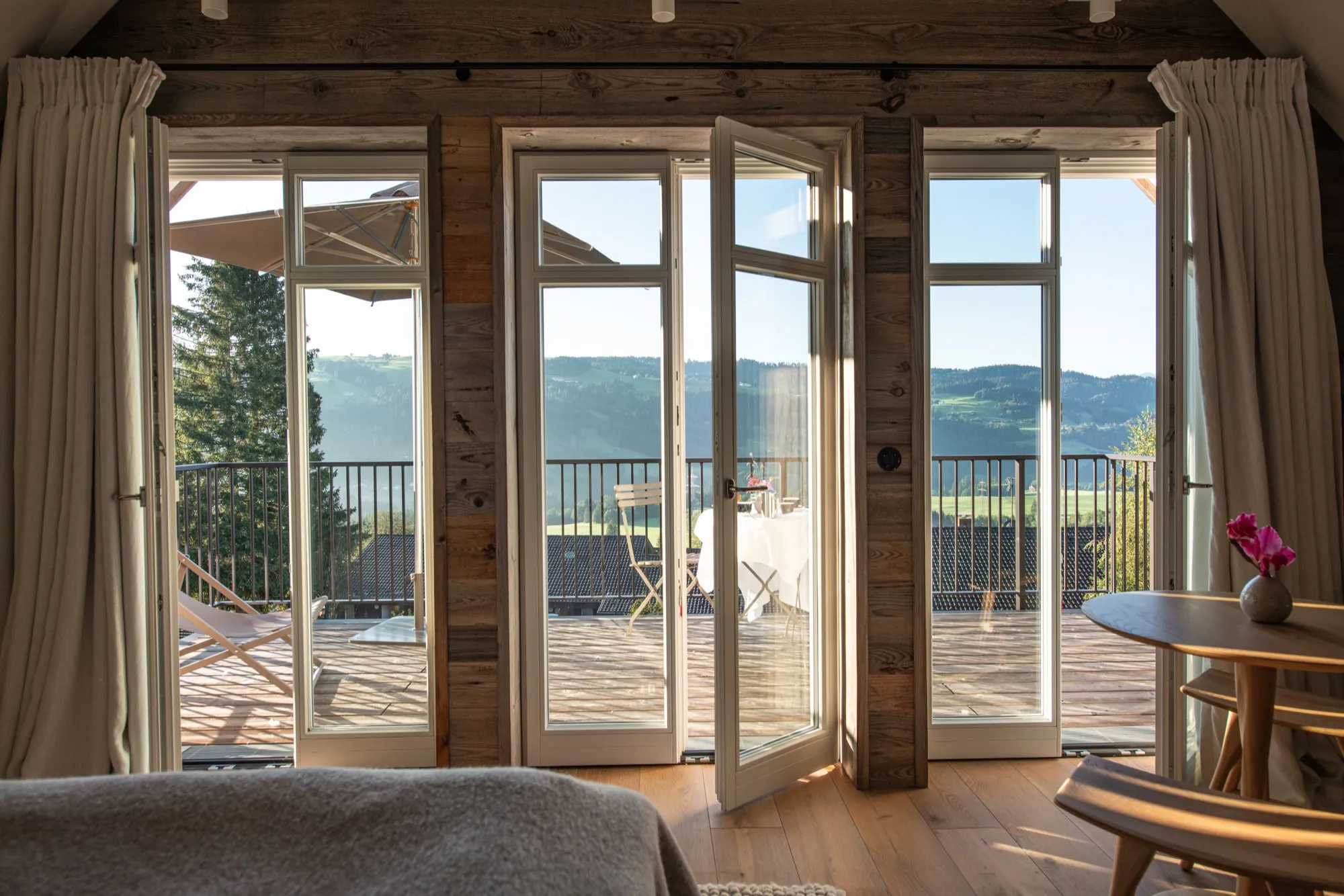 View through the open terrace doors of Suite Eight onto the balcony and the landscape beyond