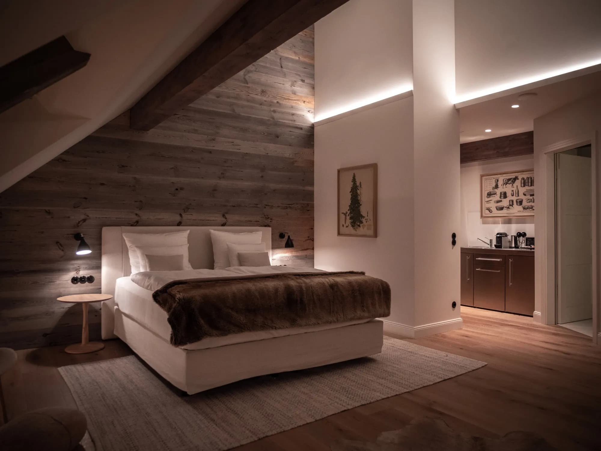 Living area of Suite Nine with the reclaimed-wood wall, the small kitchenette beyond