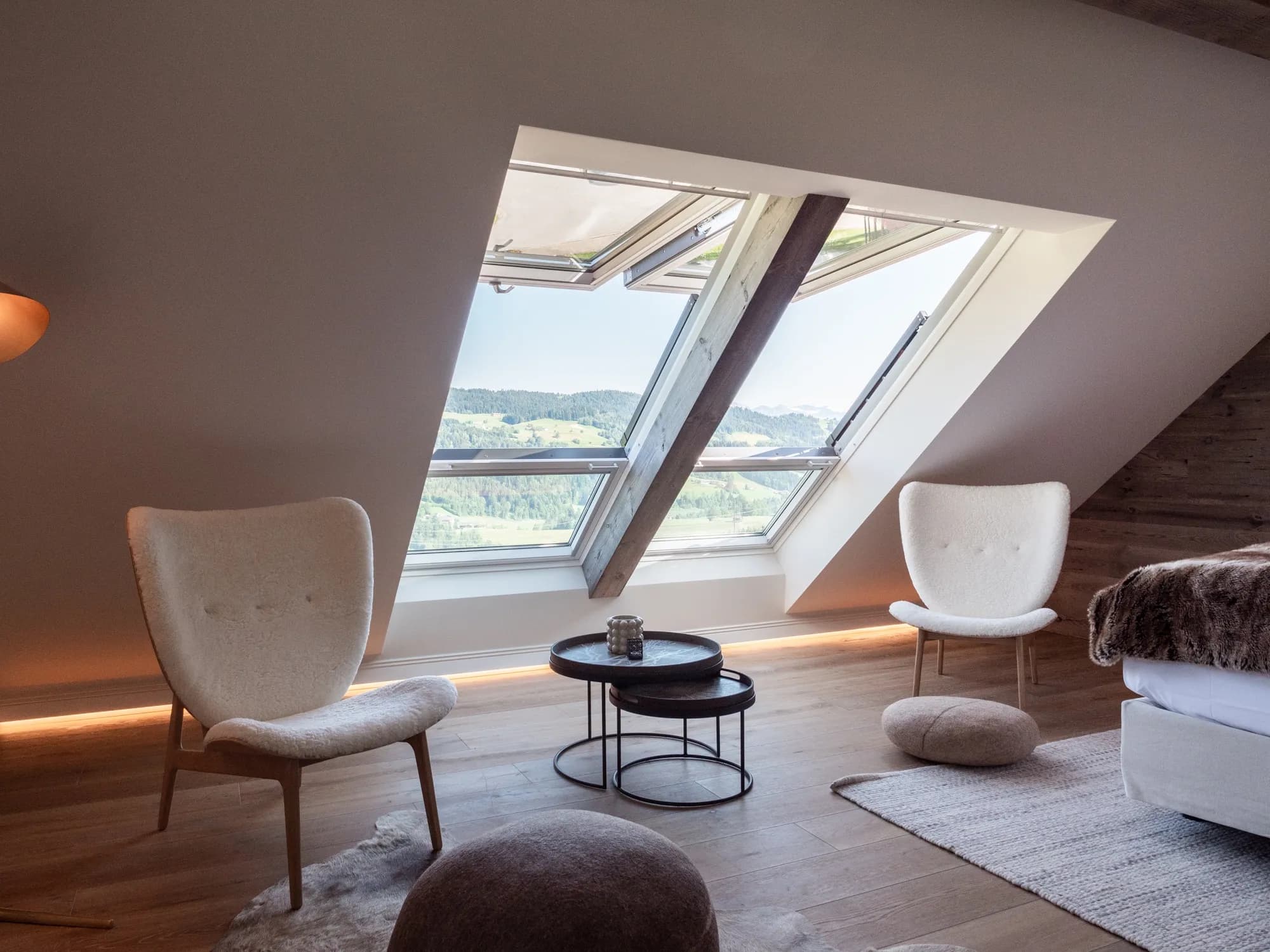 Seating area of Suite Nine beneath the dormer window, two armchairs and a low table