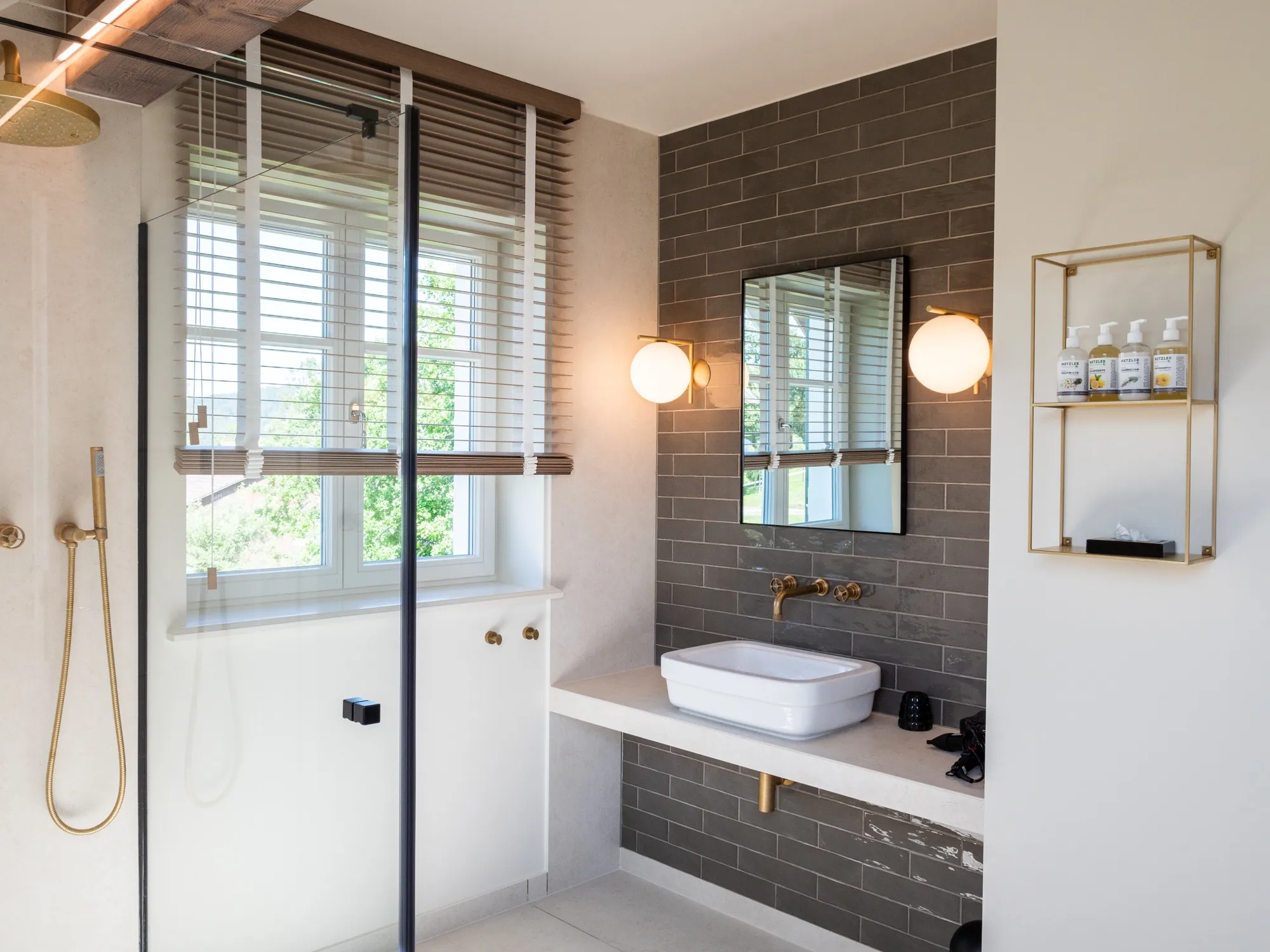 Bad der Suite Neun mit Regendusche, dunklen Fliesen und freistehendem Waschbecken