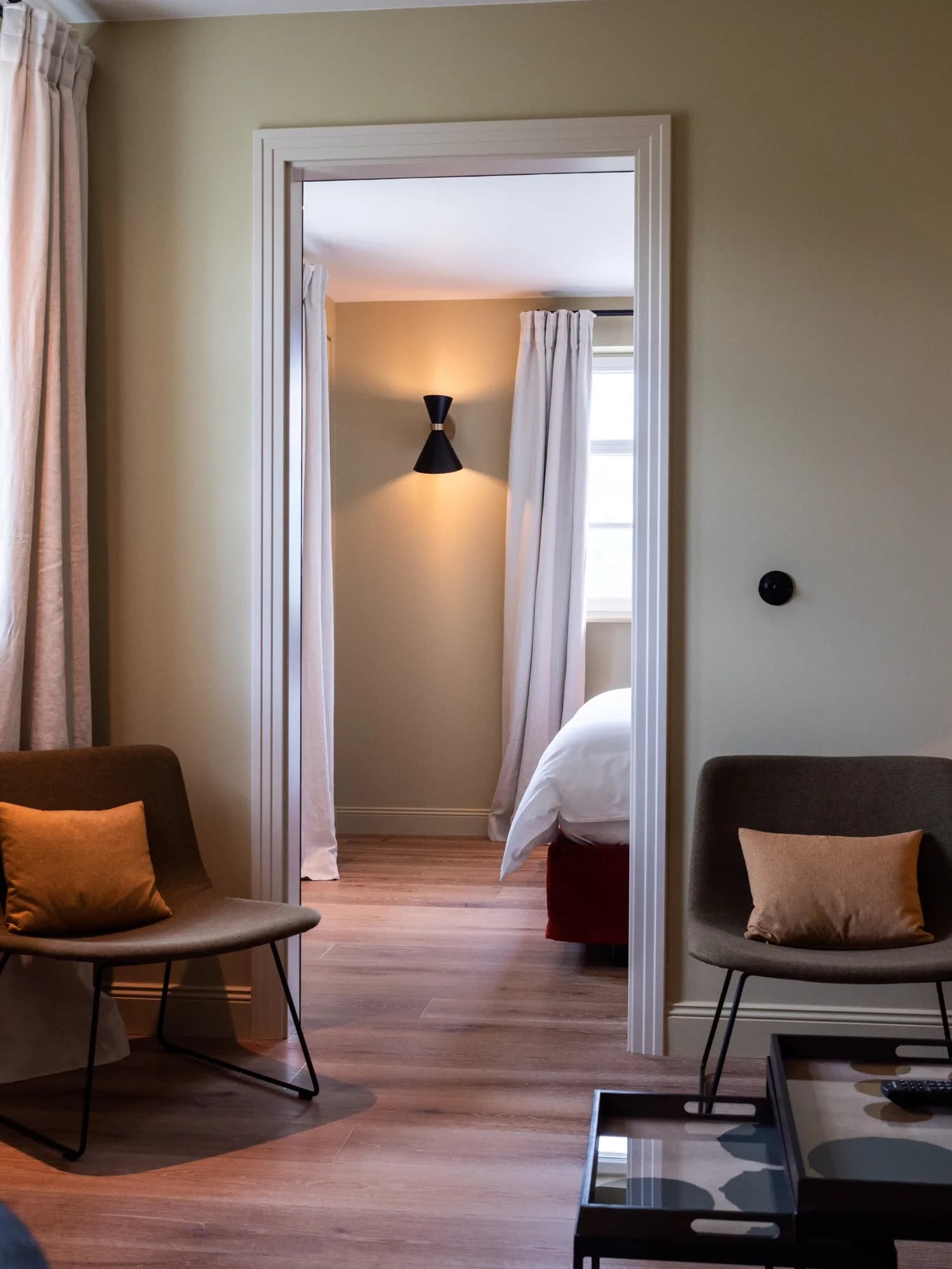 View from the seating area through the door into the bedroom of Suite Six