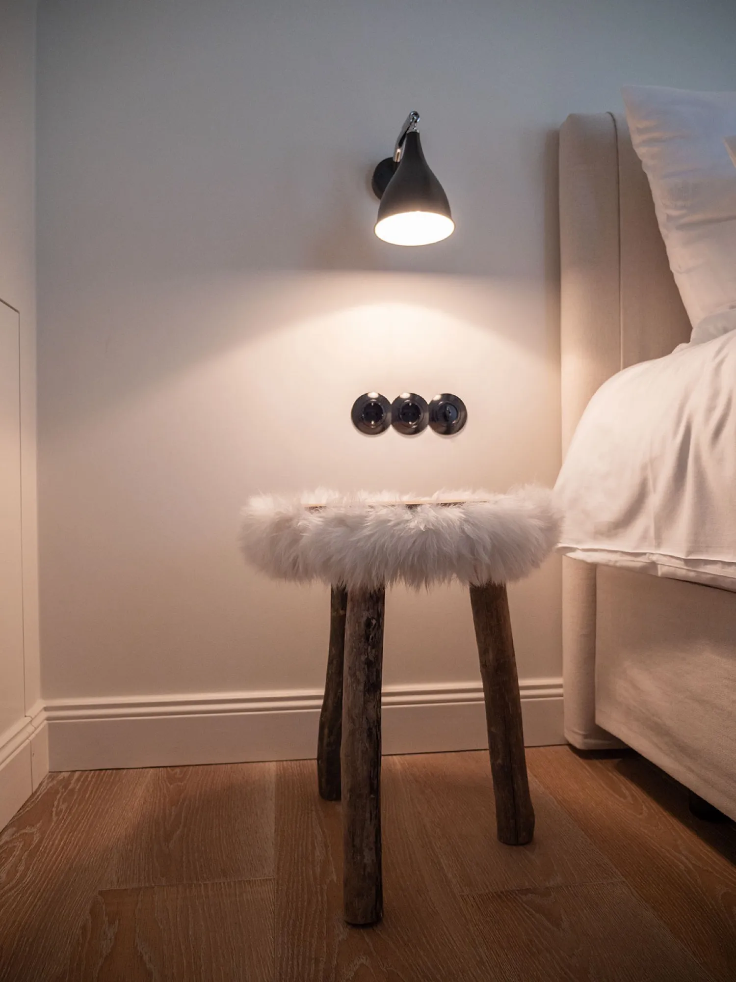 Nachttisch-Detail mit Lammfell-Hocker und Leselampe